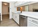 Updated kitchen boasts white cabinets, stainless steel appliances, and open view to living room at 12024 W Cross Dr # 106, Littleton, CO 80127