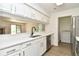 Kitchen with white cabinetry, stainless steel appliances, and views of living area at 12024 W Cross Dr # 106, Littleton, CO 80127