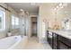 Bright bathroom featuring double vanity, separate tub, and walk-in shower at 7207 S Scottsburg Way, Aurora, CO 80016