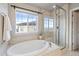 Bright bathroom with a soaking tub, walk-in shower, and large window at 7207 S Scottsburg Way, Aurora, CO 80016