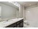 Bright bathroom featuring double sink vanity with granite countertop, tiled shower, and updated fixtures at 7207 S Scottsburg Way, Aurora, CO 80016