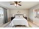 Comfortable bedroom with plush bedding, ceiling fan, and en suite bathroom with tub at 7207 S Scottsburg Way, Aurora, CO 80016