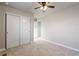 A carpeted bedroom featuring sliding closet doors, neutral walls, and an entry into another room at 7207 S Scottsburg Way, Aurora, CO 80016