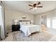 Bright bedroom features a ceiling fan, bedside tables, and an ensuite bathroom with a tub and shower at 7207 S Scottsburg Way, Aurora, CO 80016
