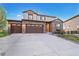Charming two-story home featuring a three-car garage, brick facade, landscaped yard and inviting front door at 7207 S Scottsburg Way, Aurora, CO 80016