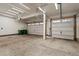 An empty three car garage with concrete floor and modern overhead lighting and garage door openers at 7207 S Scottsburg Way, Aurora, CO 80016