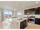 Modern kitchen with granite counters, stainless appliances, and a large island open to the dining area at 7207 S Scottsburg Way, Aurora, CO 80016