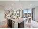 Modern kitchen with granite counters, stainless appliances, and a large island open to the dining area at 7207 S Scottsburg Way, Aurora, CO 80016