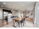 Open-concept living space with a modern kitchen, dining area, and cozy living room featuring hardwood floors and recessed lighting at 7207 S Scottsburg Way, Aurora, CO 80016