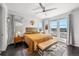 Sun-drenched main bedroom with modern decor, plush bedding, ceiling fan, and large windows at 15732 E Broncos Pl, Englewood, CO 80112