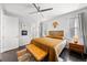 Bright bedroom featuring modern decor, wood headboard, and a leather bench in front of the windows at 15732 E Broncos Pl, Englewood, CO 80112