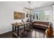Dining room featuring a rustic wood table, modern chandelier and comfortable couch at 15732 E Broncos Pl, Englewood, CO 80112