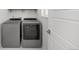 Functional laundry room with modern washer and dryer units, and organized storage at 15732 E Broncos Pl, Englewood, CO 80112