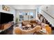 Bright living room featuring a leather couch, modern decor, and natural light from nearby windows at 15732 E Broncos Pl, Englewood, CO 80112