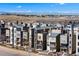 Modern townhomes with various designs showcase urban living against a backdrop of distant mountains and a clear blue sky at 15732 E Broncos Pl, Englewood, CO 80112