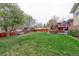 Grassy backyard featuring a deck, wooden fence, and mature trees, creating a serene outdoor retreat at 10538 Quivas St, Northglenn, CO 80234
