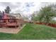 Expansive backyard with lush green lawn, a wooden deck, and mature trees, perfect for outdoor activities at 10538 Quivas St, Northglenn, CO 80234