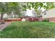 This backyard boasts a spacious grassy area, a convenient storage shed, and a charming wooden deck at 10538 Quivas St, Northglenn, CO 80234