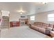 Open living space featuring a fireplace, piano, plush sofa and staircase with carpeted steps at 10538 Quivas St, Northglenn, CO 80234