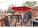 Inviting deck featuring a red umbrella, seating, and a fire pit for outdoor relaxation and entertainment at 10538 Quivas St, Northglenn, CO 80234