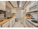 Bright kitchen with white appliances, ample cabinet space, wood countertops, and light-colored tile flooring at 16051 E Alaska Pl # 4, Aurora, CO 80017