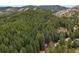 Majestic aerial view of a red roofed house nestled in a vast forest on hilly terrain at 17422 N Canyon Rd, Littleton, CO 80127