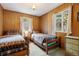 Wood-paneled bedroom features twin beds, natural light, and plush carpeting at 17422 N Canyon Rd, Littleton, CO 80127