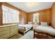 Bedroom with wood paneled walls features two beds and light-filled windows at 17422 N Canyon Rd, Littleton, CO 80127