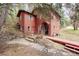 Two-story cabin-style home showcasing rustic charm with a quaint fountain, bridge and stone steps to the front door at 17422 N Canyon Rd, Littleton, CO 80127