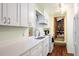 Bright kitchen with stainless steel sink, white cabinets, and open view to a library at 17422 N Canyon Rd, Littleton, CO 80127