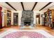 Inviting living room with stone fireplace, exposed beams, and bookshelves creating a cozy atmosphere at 17422 N Canyon Rd, Littleton, CO 80127