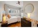 Comfortable bedroom featuring hardwood floors, a ceiling fan and a golden round mirror at 945 N Washington St # 201, Denver, CO 80203