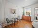 Cozy dining area with hardwood floors, a small table with chairs, and a built-in cabinet under the window at 945 N Washington St # 201, Denver, CO 80203