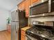 Close-up of kitchen appliances: stainless steel fridge, microwave, and gas range, with sleek design at 945 N Washington St # 201, Denver, CO 80203