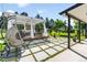 Outdoor living with a pergola-covered patio with lounge seating and hanging chair on a tiled yard at 9232 N Surrey Dr, Castle Rock, CO 80108