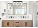 Bathroom featuring a double sink vanity with modern fixtures, a large mirror and bright lighting at 9232 N Surrey Dr, Castle Rock, CO 80108