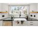 Charming farmhouse sink beneath a sunny window with a subway tile backsplash at 9232 N Surrey Dr, Castle Rock, CO 80108