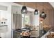 Modern kitchen with a stainless steel refrigerator, black countertops, and contemporary lighting fixtures at 9232 N Surrey Dr, Castle Rock, CO 80108