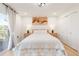 Well-lit bedroom with a large window, white walls and linen, and sleek, light-colored nightstands at 9232 N Surrey Dr, Castle Rock, CO 80108