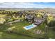 Expansive aerial view of a beautiful property with a pool and large yard, mountains in the distance at 7624 Russell Ct, Arvada, CO 80007