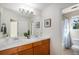 Bathroom featuring dual sinks, wood cabinets, and a shower/tub combo with a blue patterned shower curtain at 7624 Russell Ct, Arvada, CO 80007