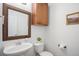 Cozy half bathroom with decorative mirror, cabinet, and sink basin at 7624 Russell Ct, Arvada, CO 80007
