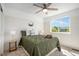 Bright bedroom featuring a ceiling fan, a large window with views, and stylish decor at 7624 Russell Ct, Arvada, CO 80007