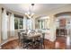 Elegant dining room with wood floors and decorative chandelier, with large bright windows and archway to kitchen at 7624 Russell Ct, Arvada, CO 80007