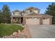 Charming two-story brick home with a three-car garage and well-manicured lawn and rock garden at 7624 Russell Ct, Arvada, CO 80007