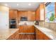 Well-equipped kitchen with wooden cabinetry, granite countertops, and stainless steel appliances, combining style and functionality at 7624 Russell Ct, Arvada, CO 80007
