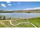 Scenic lake view with walking path winding through lush greenery at 7624 Russell Ct, Arvada, CO 80007