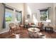 Comfortable living room featuring hardwood floors, neutral tones, and abundant natural light streaming through large windows at 7624 Russell Ct, Arvada, CO 80007