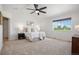 Spacious main bedroom with a large window, soft carpet, and a ceiling fan, offering a relaxing retreat at 7624 Russell Ct, Arvada, CO 80007