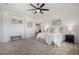 Spacious main bedroom with soft carpet, ceiling fan, and a view of the en-suite bathroom at 7624 Russell Ct, Arvada, CO 80007